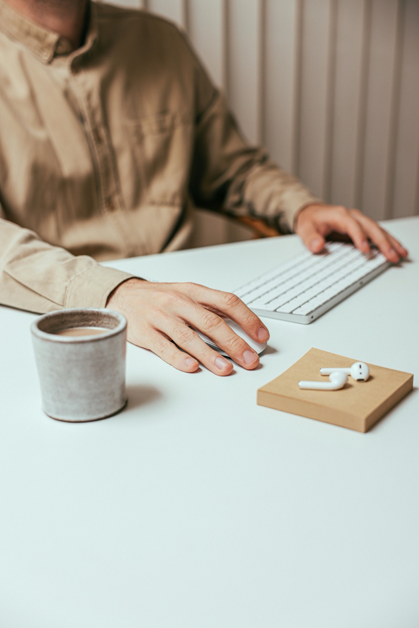 Man sieht einen Mann vom Hals abwärts, der in seinem Coworking Space in Landshut an einem Projekt arbeitet. Er wirkt fokussiert und konzentriert.