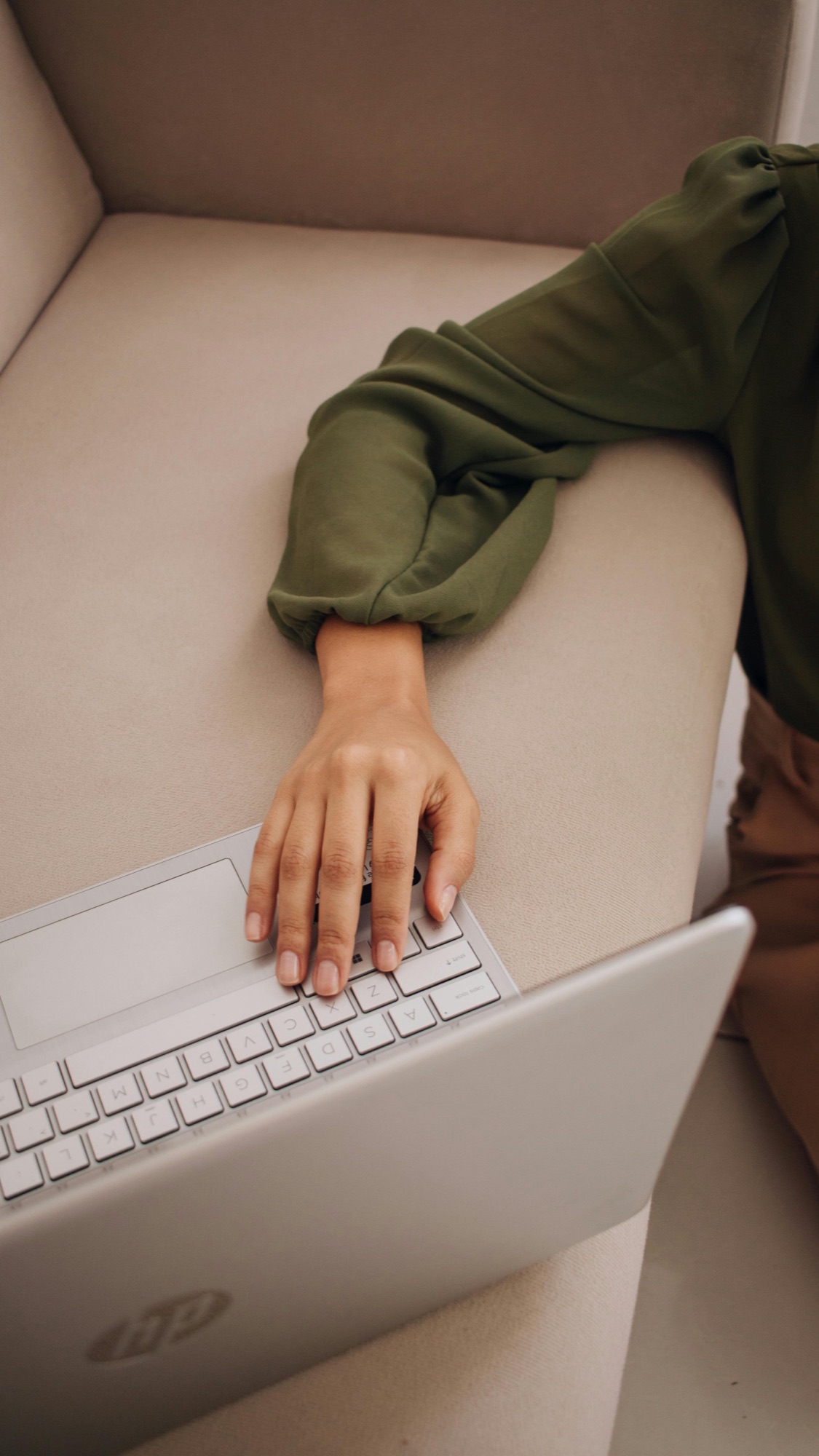 Eine Frau, die zuhause auf dem Sofa arbeitet und dabei auf dem Boden sitzt. Ein gemütlicher Coworking Space wäre vielleicht die bessere Lösung